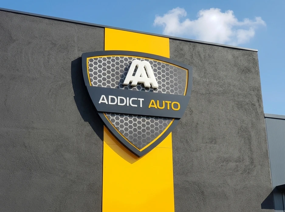 Façade extérieure d'un garage automobile avec enseigne murale en relief "Addict Auto"