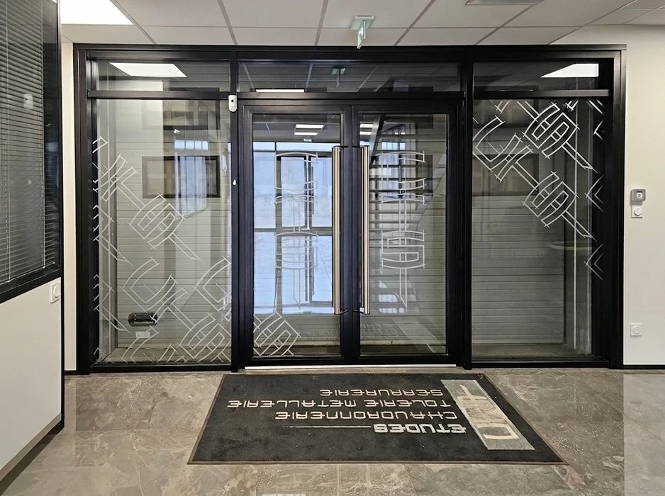 Entrée professionnelle avec double porte vitrée à cadre aluminium noir, poignées inox tubulaires