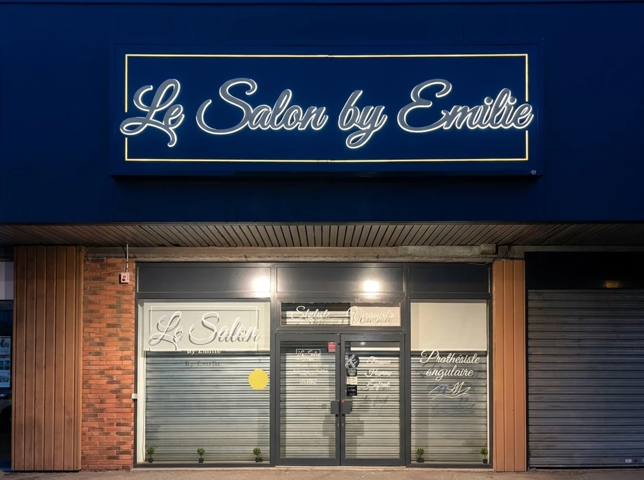Devanture nocturne d'un salon de coiffure et beauté « Le Salon by Emilie »