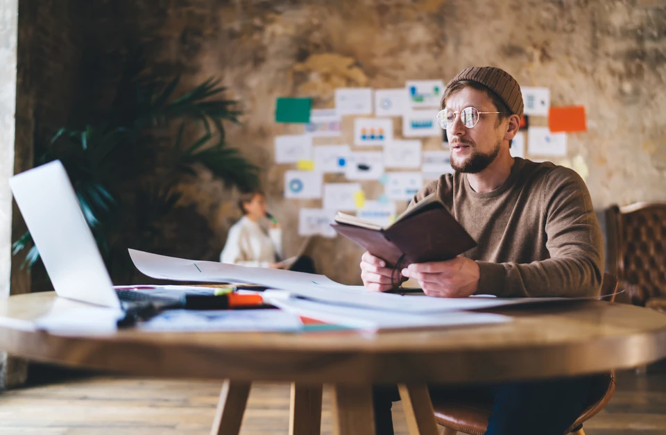 Personne travaillant sur ordinateur portable dans un bureau, consultant des données publicitaires et graphiques analytiques à l'écran